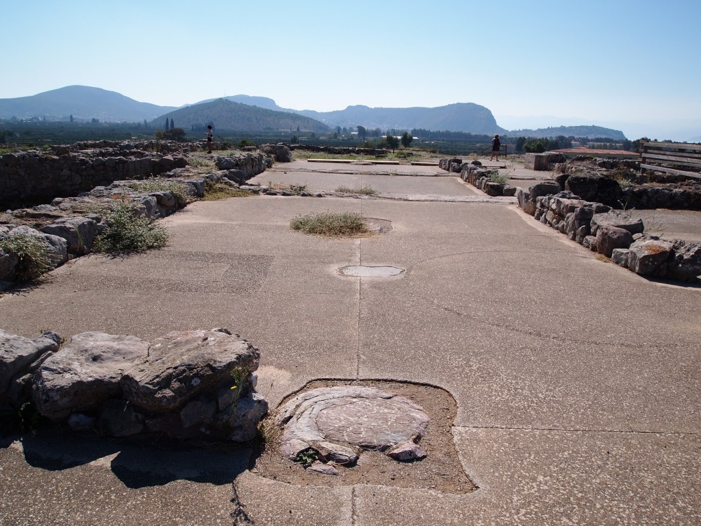 Palatial megaron at Tiryns with multiple phases visible. The position of the hearth and the throne are outlined in the foreground, and the picture was taken from the north. Photo by Rebecca Worsham.