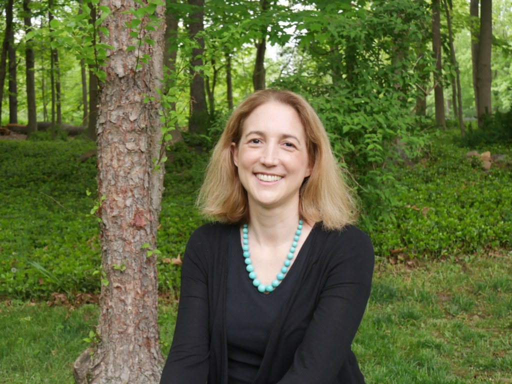 Photo of Dr. Blair Fowlkes Childs in front of trees and greenery. 