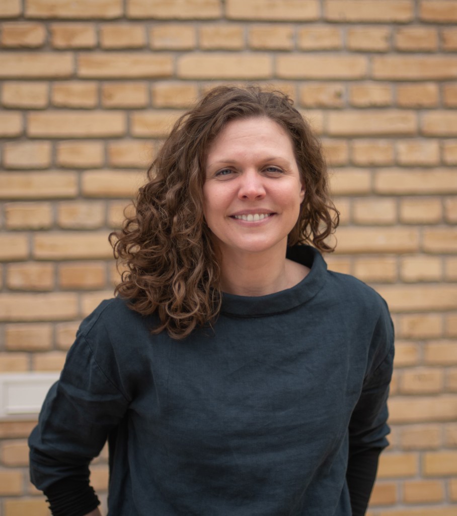 Headshot of Dr. Murphy, who is standing in front of a brick wall. 