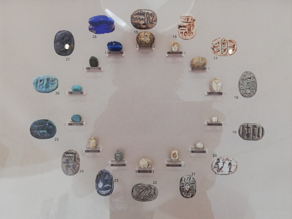 A collection of stone and faince scarabs on display (laid out in a circular fashion) in the Museo Regionale, Trapani .