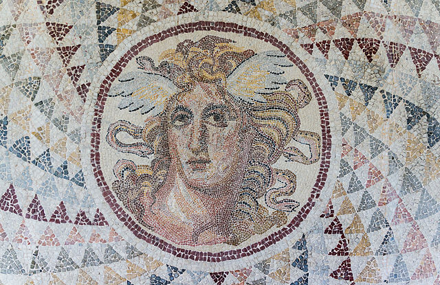 Mosaic with the gorgon Medusa in the centre of the image. She has snakes radiating outwards from her head, as if her hair. 