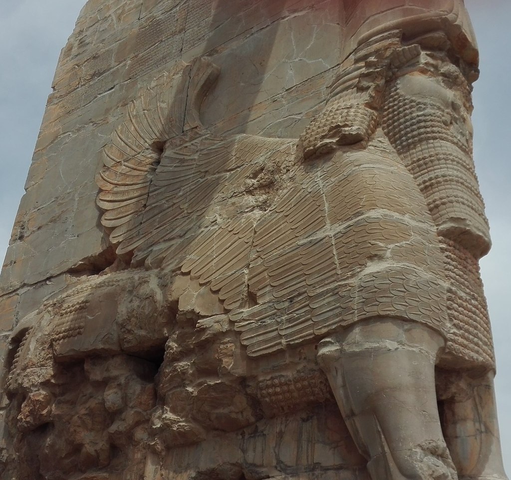 Image of Lamassu, a figure from Mesopotamian mythology, who has a bull's body with the addition of wings, and a human head.