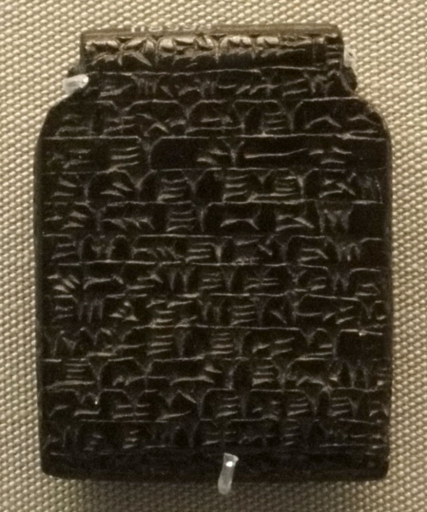 Photo of a brown inscribed amulet .