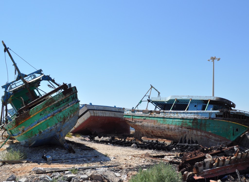 two migrant boats deteriorating on the harbour of Portopalo