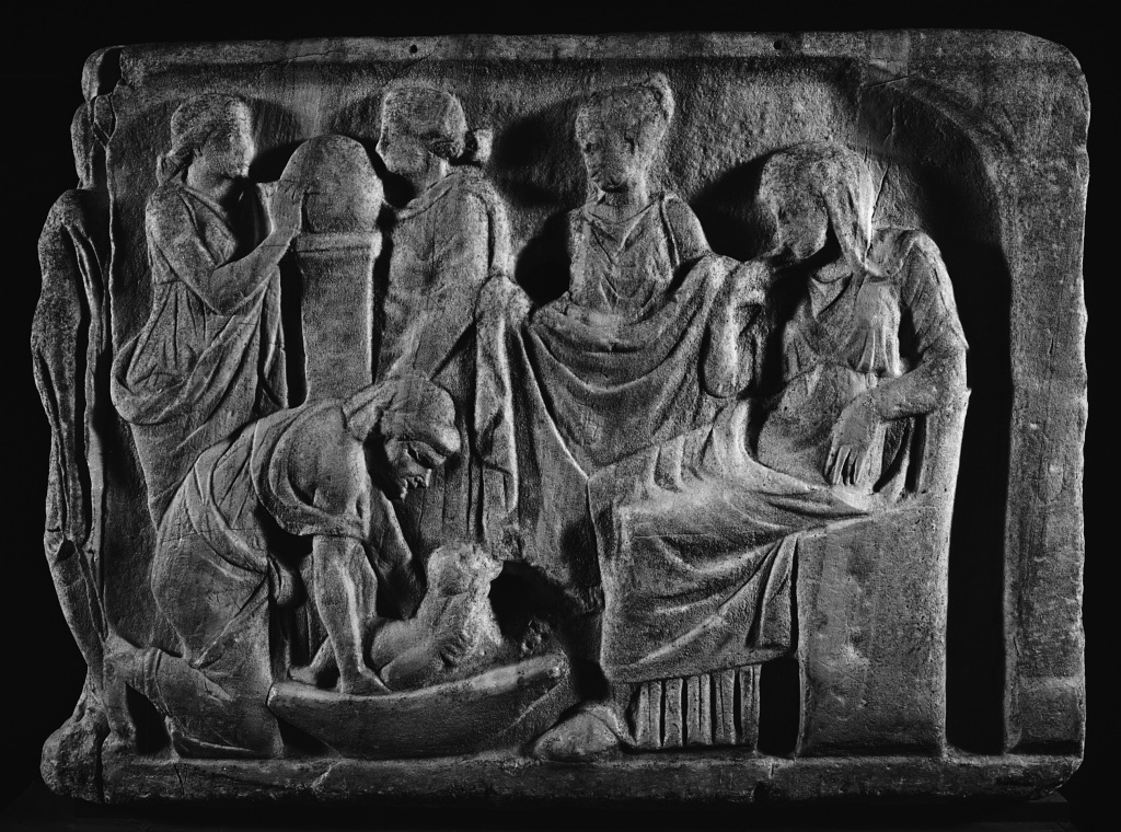 Biographical Sarcophagus Bath Scene, short end, showing a first bath scene, right after birth. A nurse washes the infant while the mother looks on from a chair. Attendants represented as muses consult a globe about the infant’s future