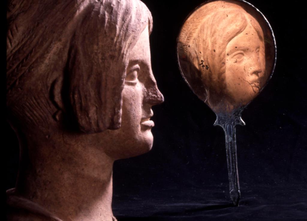 Etruscan terracotta head reflected in Etruscan bronze mirror