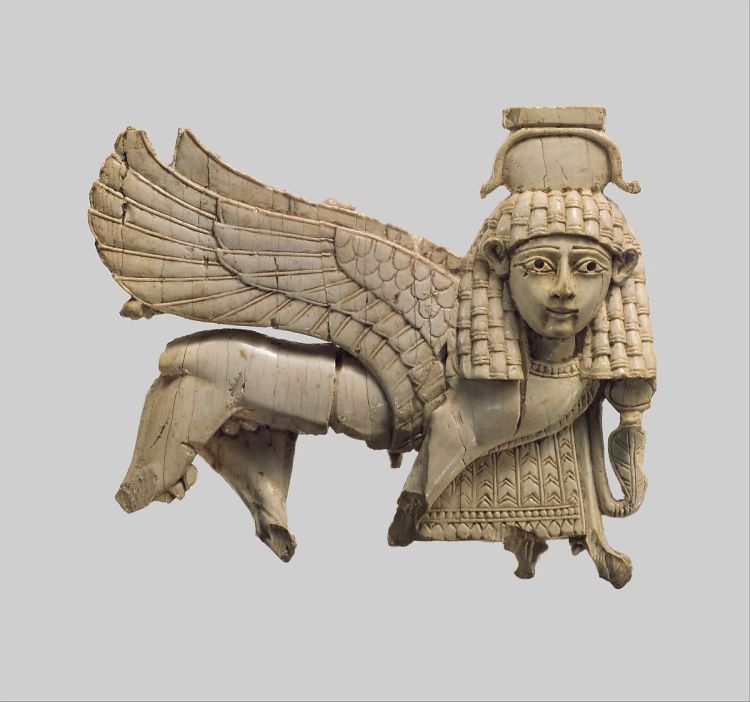 a light grey openwork plaque depicts a walking sphinx. It is missing most of its legs, but has very intricate patterns on its wings, headdress, and collar.