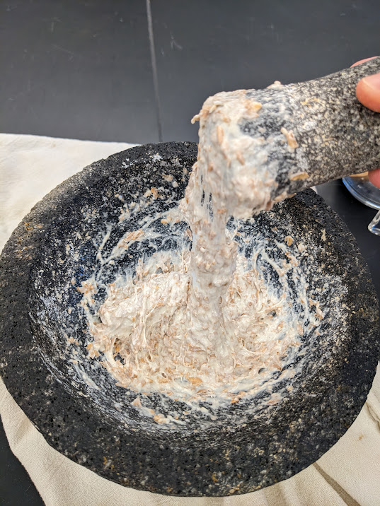 A motar and pestle showing a thick dough made with alica