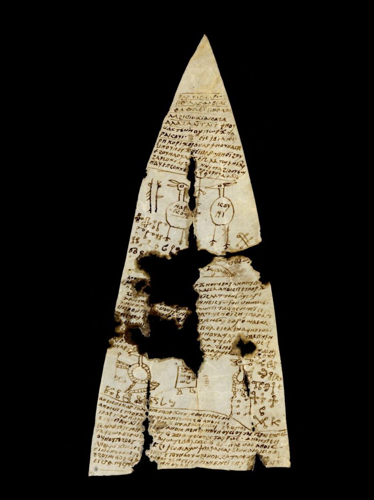 A triangular white/yellow piece of parchment with Coptic writing and several duck-like figures. 