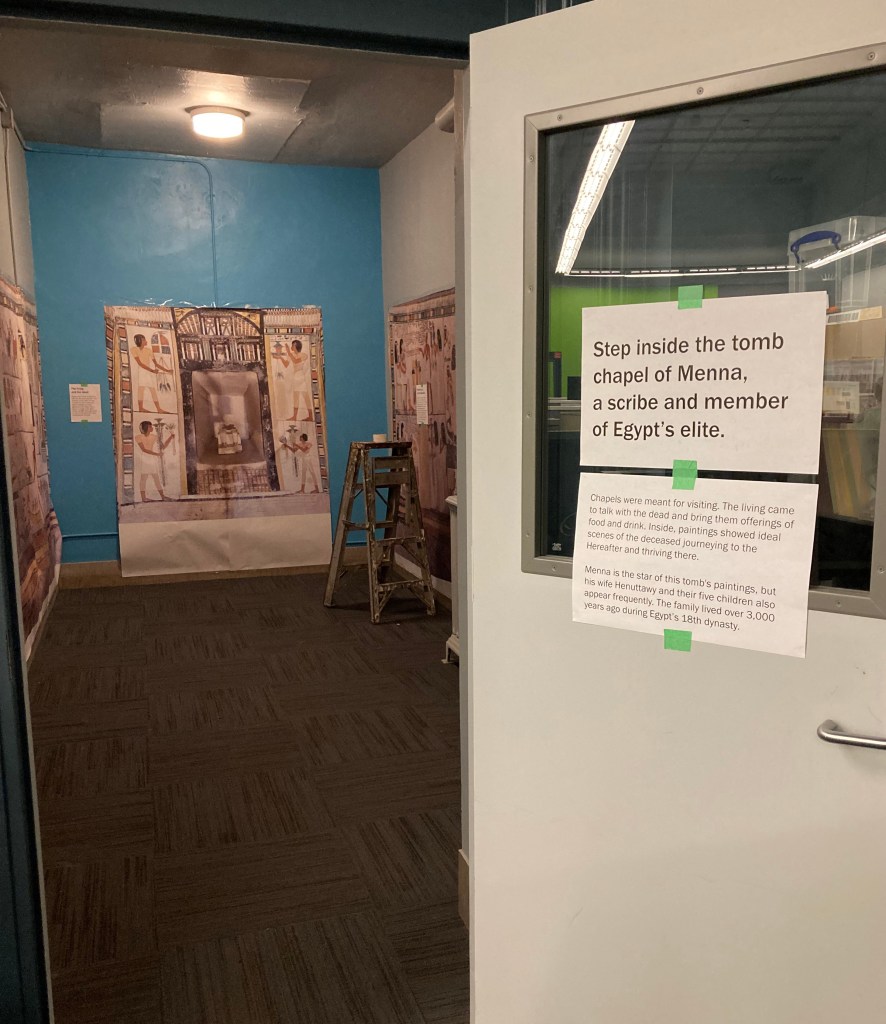 Image of a room with several large printed posters that mock up an ancient Egyptian tomb.