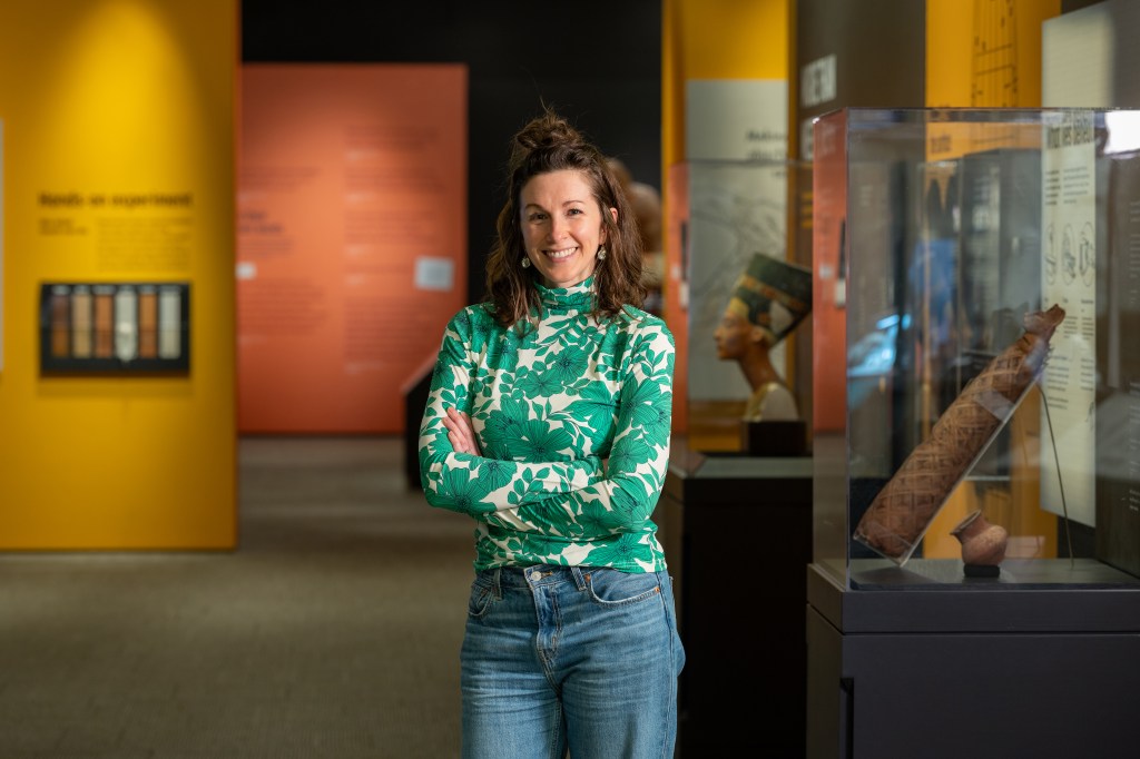 Image of a white woman with brown hair standing in a museum gallery