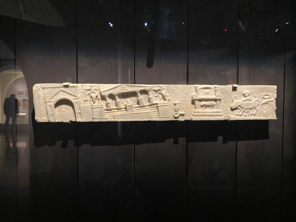 A long rectangular slab of marble decorated with the scene of an earthquake, in which several of the monuments are shown leaning towards the side.